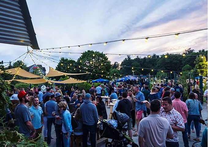 outdoor venue with many people and strung lights overhead
