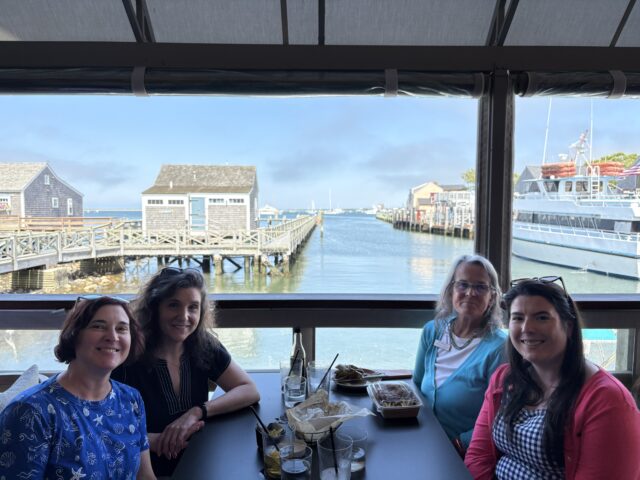 group of friends at a table on the water Nantucket
